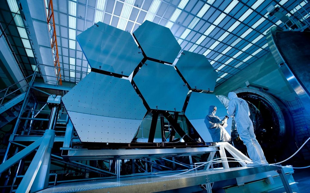 Engineers working inside a futuristic innovation lab with advanced hexagonal technology panels