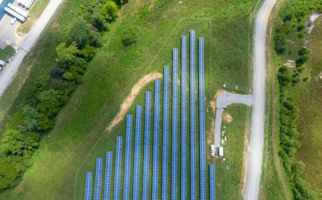 Aerial view of AI-optimized solar panel installation in a green field - new innovations